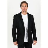 Man wearing a black blazer over a white shirt on a white background