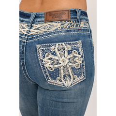 Close-up of embroidered back pocket featuring rhinestones, sequins, faux leather, and western cross design.