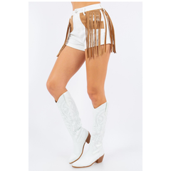 Side view of white western shorts with long tan fringe